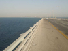 A photograph of a causeway stretching off into the distance beside a body of water