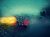 An abstract photograph of a car as seen through a rain streaked window