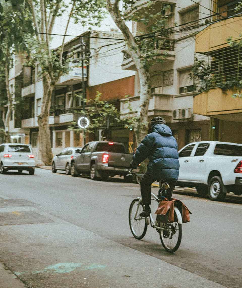 A photograph of a man riding down a city street on a bicycle