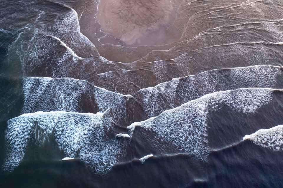 A painting of dark blue ocean waves cresting