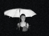 A woman reads a book underneath a lit umbrella