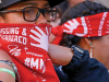 A close photograph of a protestor, whose red bandana reads Missing and Murdered