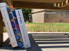 A photograph of the three books discussed below, spines facing the viewer, in shade beneath a bench outside