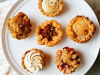 A photograph of six pastries on a white serving platter from above