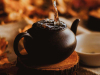 Water from above overfills the steeping basket of a tea pot