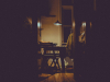 A photograph of a dimly lit nook in an apartment where a writing desk is set up