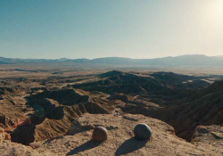 A still photograph of two rocks sitting on a cliff