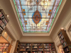 A photograph of the interior of Escaramuza looking up toward the intricate stained glass skylight