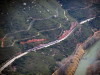 A distant shot of a train winding its way through a mountainous countryside