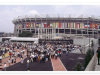 A crowd throngs into a stadium lined with flags from around the world