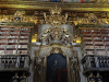 Two large, ornate and wooden bookcases flanking a gilded door