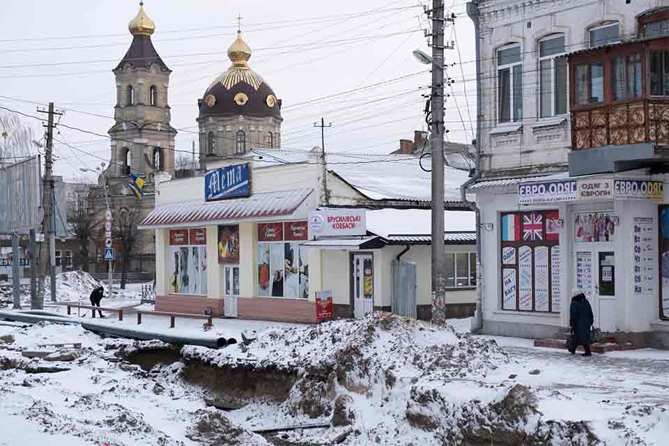 A photograph of a gritty urban scene, coated in dirty snow