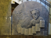 A stone sculpture of Ismail Kadare surrounded by books