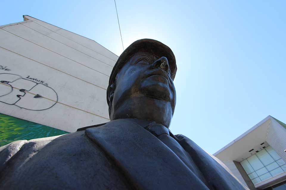 A photograph of a statue taken from down low with the sun's halo encircling the head