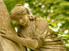 A photograph of a statue of a female figure clinging to a wall