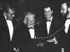 A black and white photo of four men standing in tuxedos